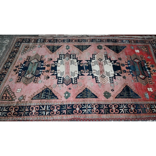 743 - A mid-century Turkish rug, the faded red ground rug with geometric design, 228 cm x 164 cm