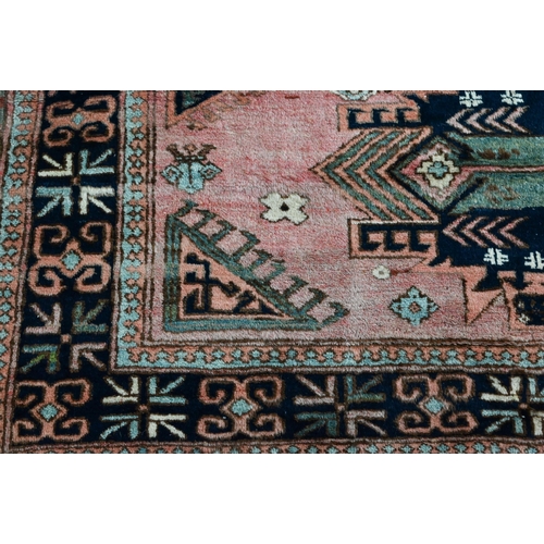 743 - A mid-century Turkish rug, the faded red ground rug with geometric design, 228 cm x 164 cm