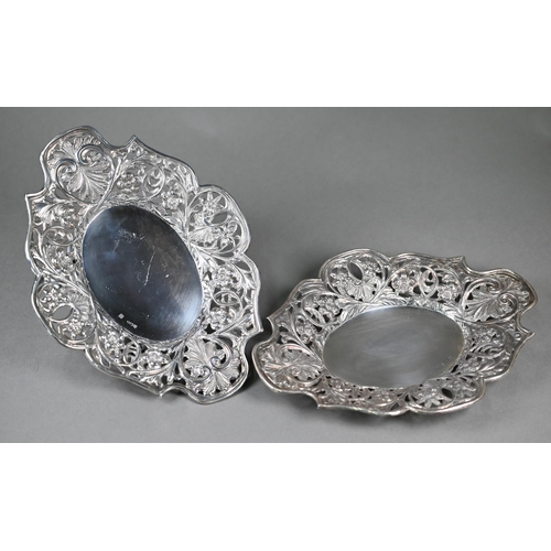 131 - A pair of Victorian silver oval dishes with richly embossed and pierced floral and foliate borders, ... 