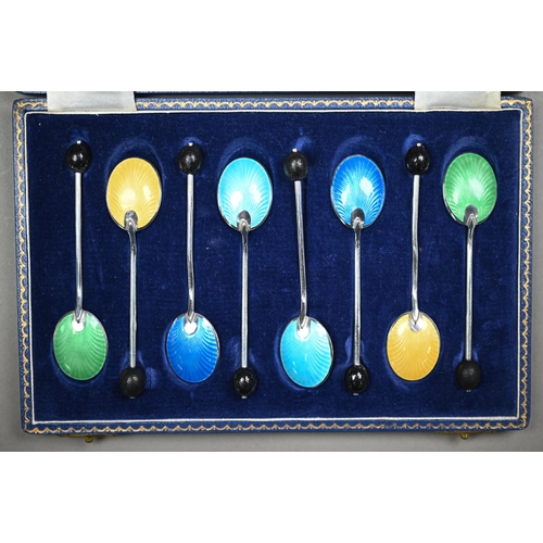 138 - A cased set of eight coffee spoons with coloured enamel backs and bean finials, Birmingham 1957, to/... 