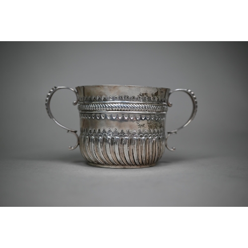 144 - A late Victorian silver porringer in the 17th Century manner, with twin scroll handles and embossed ... 