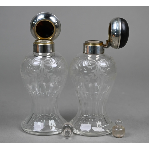 19 - A pair of cut glass cologne bottles of waisted form with wheel-etched swags, with silver and tortois... 