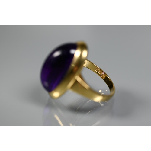 228 - A contemporary ring set with oval cabochon amethyst, yellow metal set stamped 750 Ka, size M, amethy... 