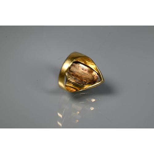 230 - A contemporary style ring with closed back elliptical moonstone (rubbed) in yellow metal setting sta... 