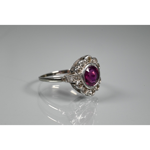 247 - A ruby and diamond cluster ring, the central circular ruby with ten diamonds around, diamond set sho... 