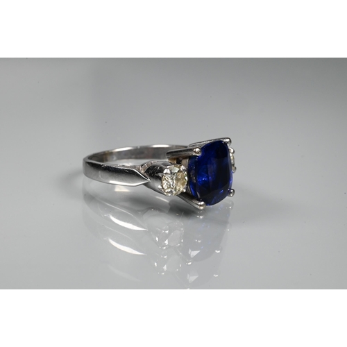 255 - A modern sapphire and diamond three stone ring, the central blue cushion cut sapphire with two round... 