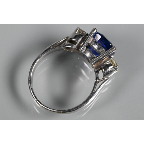 255 - A modern sapphire and diamond three stone ring, the central blue cushion cut sapphire with two round... 