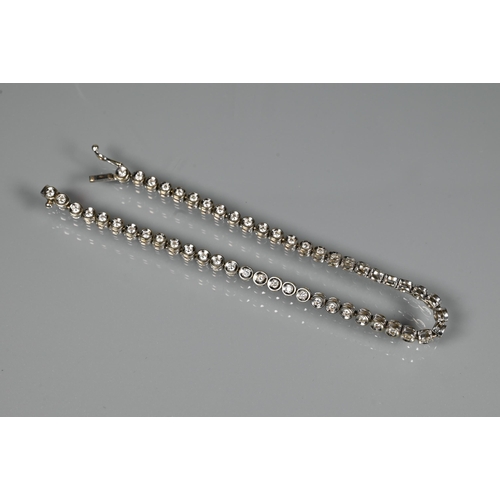 256 - A diamond line bracelet formed of fifty-two collet-set diamonds, white metal stamped 750, concealed ... 