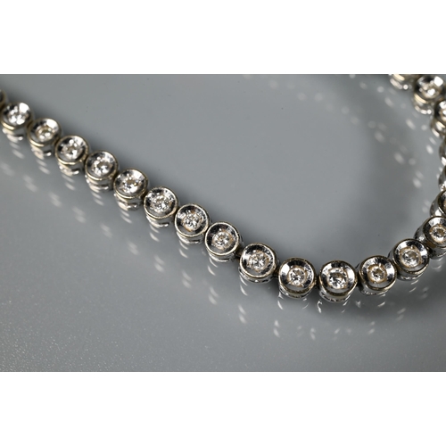 256 - A diamond line bracelet formed of fifty-two collet-set diamonds, white metal stamped 750, concealed ... 