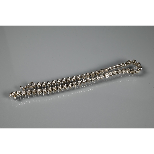 256 - A diamond line bracelet formed of fifty-two collet-set diamonds, white metal stamped 750, concealed ... 