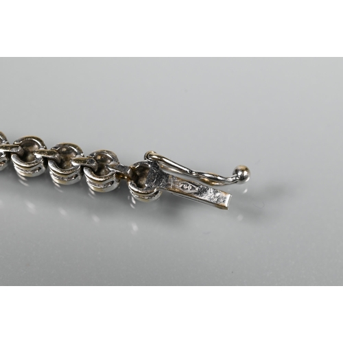 256 - A diamond line bracelet formed of fifty-two collet-set diamonds, white metal stamped 750, concealed ... 