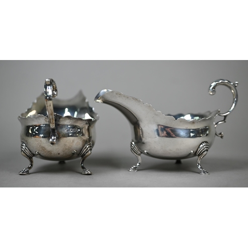 30 - A pair of silver sauce boats in the Georgian manner, with cut rims, scroll handles and hoof feet, Th... 