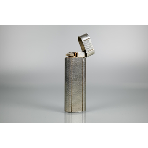 318 - Cartier - A silver-plated lighter of flattened cylindrical form, 7 x 2.5 cm