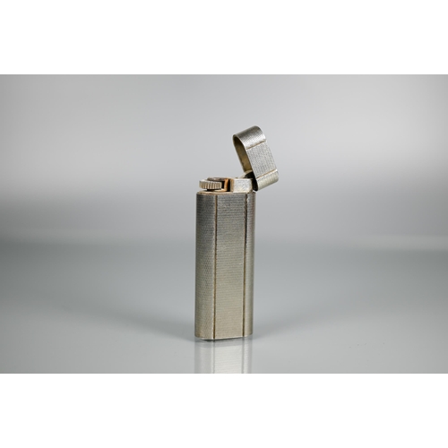 318 - Cartier - A silver-plated lighter of flattened cylindrical form, 7 x 2.5 cm