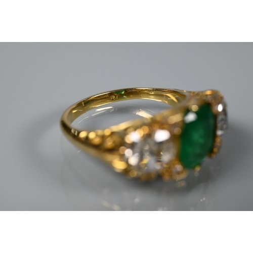 320 - An early 20th century ring with central cushion cut natural emerald with brilliant cut diamond to ea... 