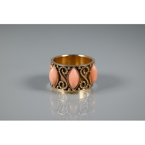 322 - A yellow metal wide band with applied rope twists and set with oval coral cabouchons, stamped 14k, s... 