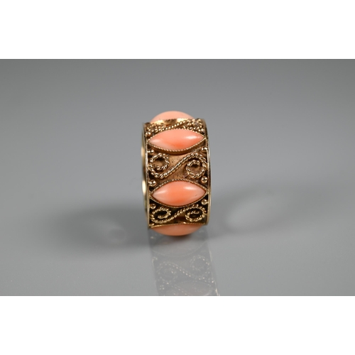 322 - A yellow metal wide band with applied rope twists and set with oval coral cabouchons, stamped 14k, s... 