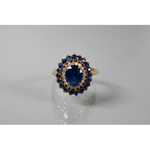 325 - A sapphire and diamond cluster ring, the central natural sapphire with two rows of diamonds and sapp... 