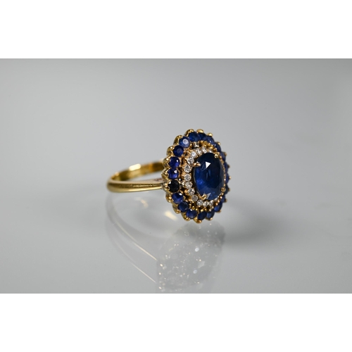 325 - A sapphire and diamond cluster ring, the central natural sapphire with two rows of diamonds and sapp... 