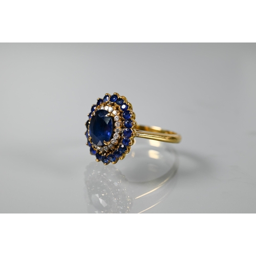 325 - A sapphire and diamond cluster ring, the central natural sapphire with two rows of diamonds and sapp... 