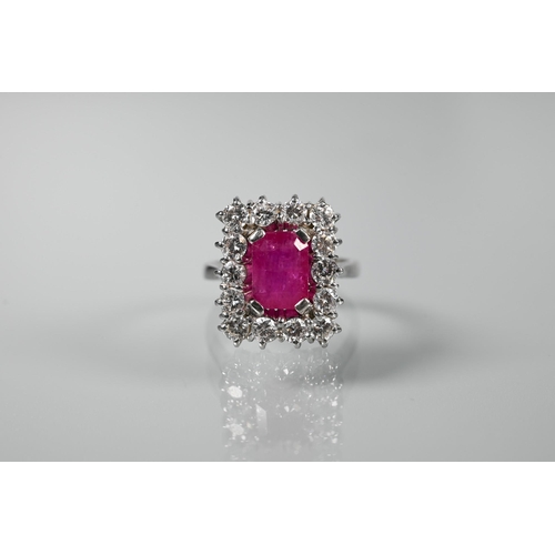 330 - A rectangular cluster ring, the central rectangular step-cut natural ruby with fourteen diamonds aro... 