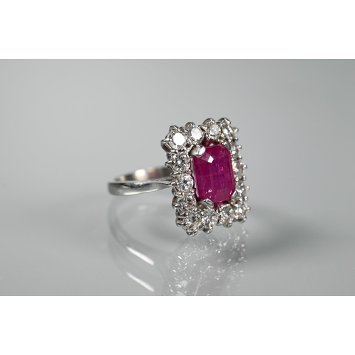 330 - A rectangular cluster ring, the central rectangular step-cut natural ruby with fourteen diamonds aro... 