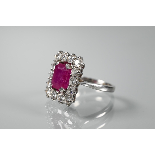 330 - A rectangular cluster ring, the central rectangular step-cut natural ruby with fourteen diamonds aro... 