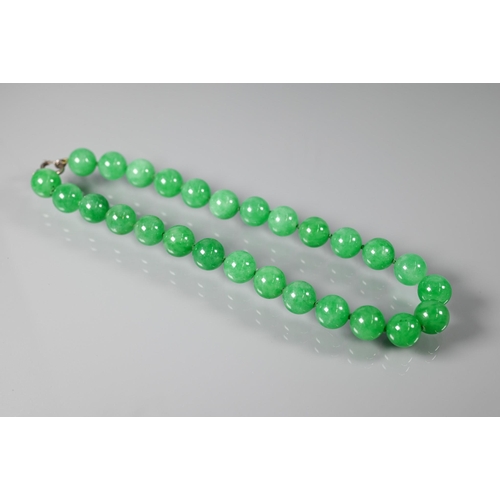 352 - A uniform row of green jade beads, double knotted throughout, each bead approx 1.4 cm diam, 41 cm lo... 