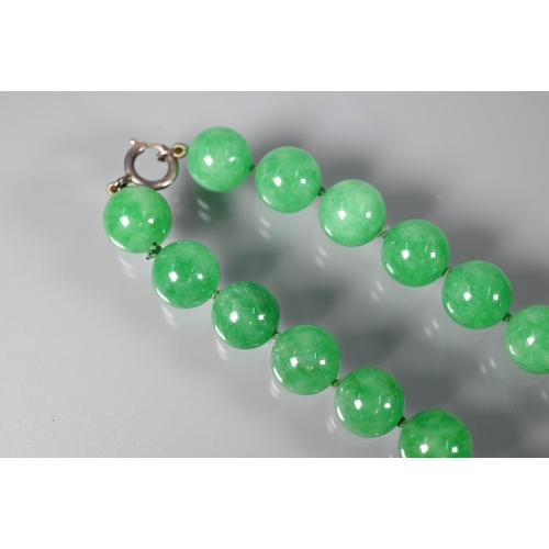 352 - A uniform row of green jade beads, double knotted throughout, each bead approx 1.4 cm diam, 41 cm lo... 