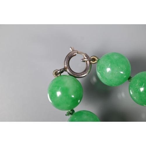 352 - A uniform row of green jade beads, double knotted throughout, each bead approx 1.4 cm diam, 41 cm lo... 