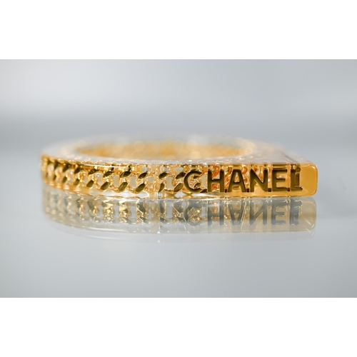 354 - Chanel - A vintage lucite/plexi shaped bangle/bracelet with embedded Chanel motifs - chain and CHANE... 