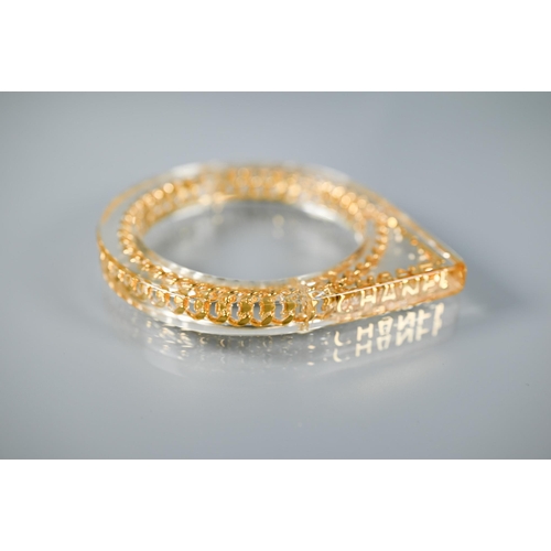 354 - Chanel - A vintage lucite/plexi shaped bangle/bracelet with embedded Chanel motifs - chain and CHANE... 