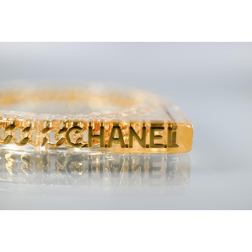 354 - Chanel - A vintage lucite/plexi shaped bangle/bracelet with embedded Chanel motifs - chain and CHANE... 