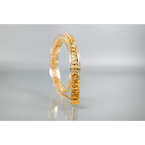 354 - Chanel - A vintage lucite/plexi shaped bangle/bracelet with embedded Chanel motifs - chain and CHANE... 