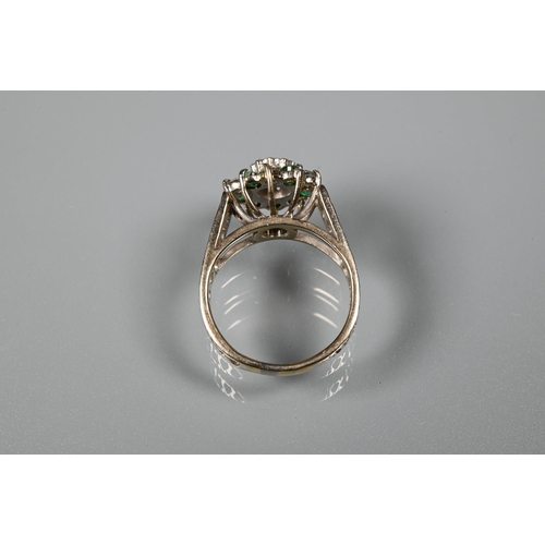 371 - A 1970s emerald and diamond cluster ring, the central bezel mounted diamond surrounded by five emera... 