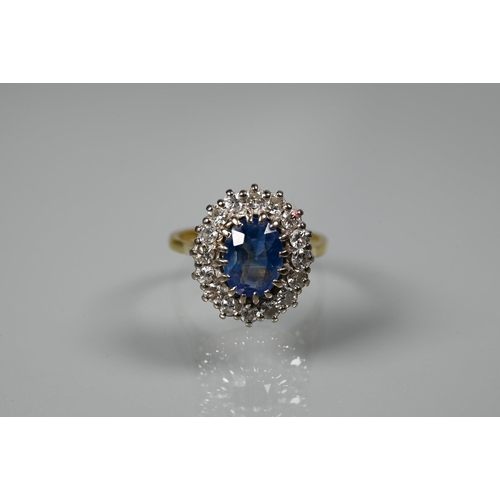 375 - An oval sapphire and diamond ring, the claw set blue sapphire surrounded by sixteen claw set diamond... 