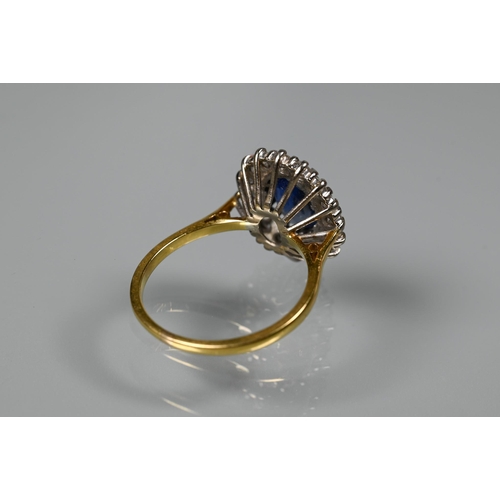 375 - An oval sapphire and diamond ring, the claw set blue sapphire surrounded by sixteen claw set diamond... 