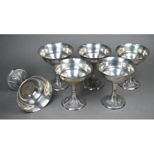 42 - A set of six Continental white metal champagne saucers with floral embossed and chased bases, stampe... 