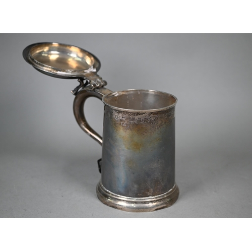 75 - A George II silver tankard of plain tapering cylindrical form, the flattened dome hinged lid with op... 