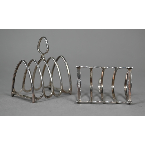 84 - A pair of Edwardian silver baluster peppers, Sheffield 1909, to/w a small pair of toast racks, Sheff... 