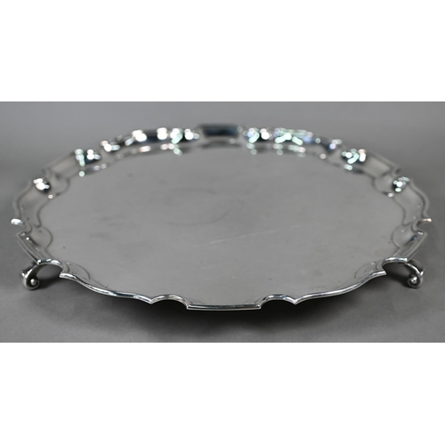 96 - A large silver salver with shaped and moulded rim, on three scroll feet, 41oz, 35.5cm diameter