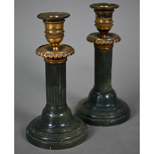 1019 - A pair of Empire candlesticks with gilt metal sockets and capitols, on turned and fluted green onyx ... 