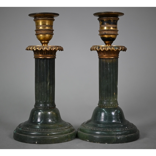 1019 - A pair of Empire candlesticks with gilt metal sockets and capitols, on turned and fluted green onyx ... 