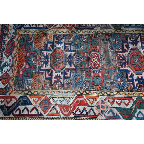 723 - An antique Caucasian Kazak rug, the the four geometric lozenge design on red ground, 140 cm x 90 cm,... 