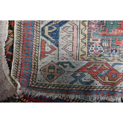 723 - An antique Caucasian Kazak rug, the the four geometric lozenge design on red ground, 140 cm x 90 cm,... 
