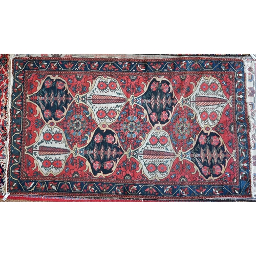 725 - An antique Persian Baktiari rug, the red ground with eight lozenges, loss to ends and sides, worn pi... 