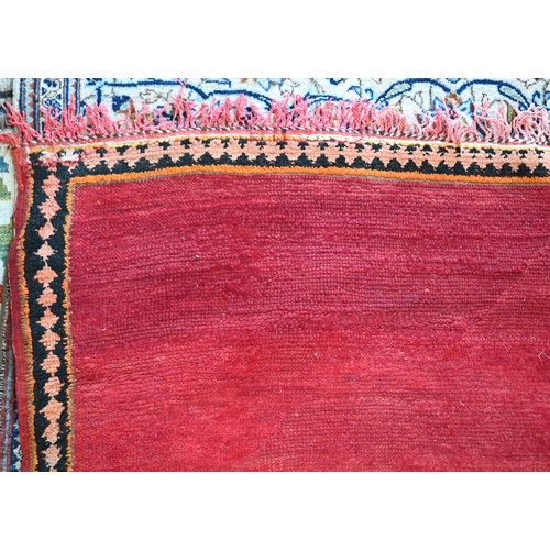 745 - A small contemporary Moroccan style carpet, the overall mottled red ground centred by a contrasting ... 