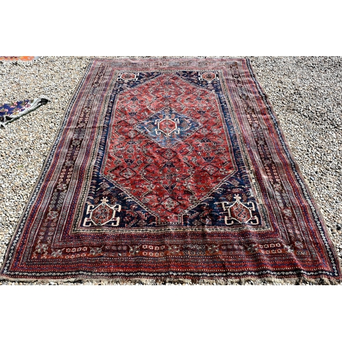 746 - An antique Persian Qashqai carpet, the red-brown ground centred by a medallion and with floral desig... 