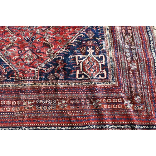 746 - An antique Persian Qashqai carpet, the red-brown ground centred by a medallion and with floral desig... 