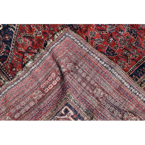 746 - An antique Persian Qashqai carpet, the red-brown ground centred by a medallion and with floral desig... 
